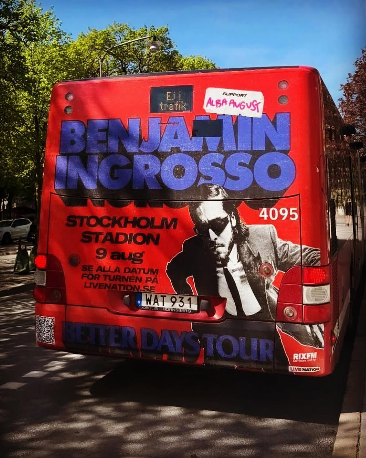 Better Days Tour campaign artwork on the back of a red city bus